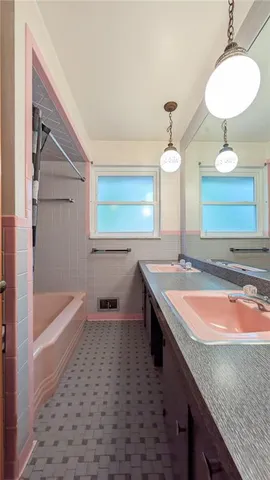 a bathroom with a granite countertop sink and a bathtub