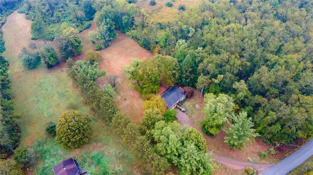 an aerial view of residential house with outdoor space and trees all around