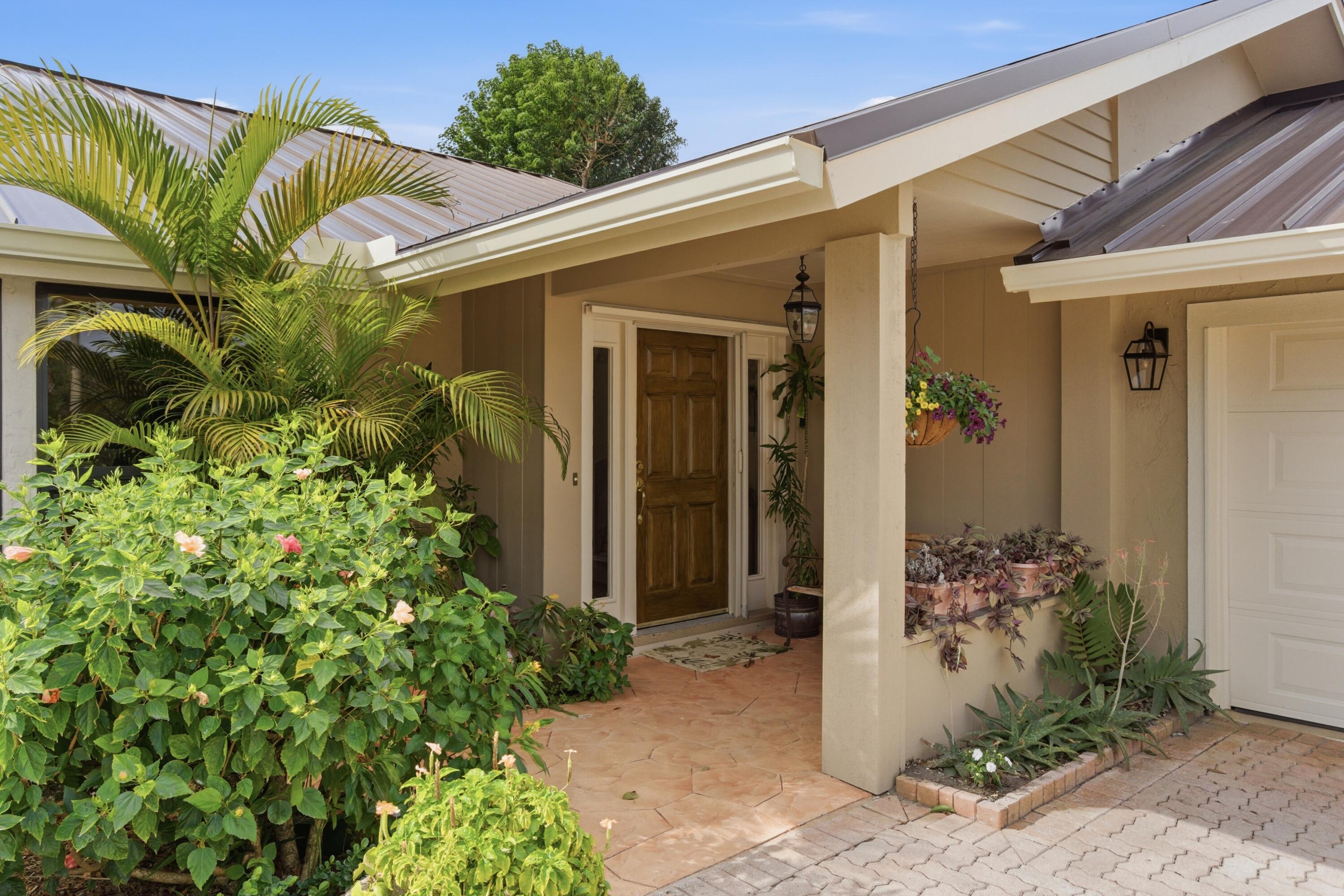 5081 Southeast Burning Tree Circle Stuart, FL 34997 - Photo 14 of 72 a view of a house with a flower garden