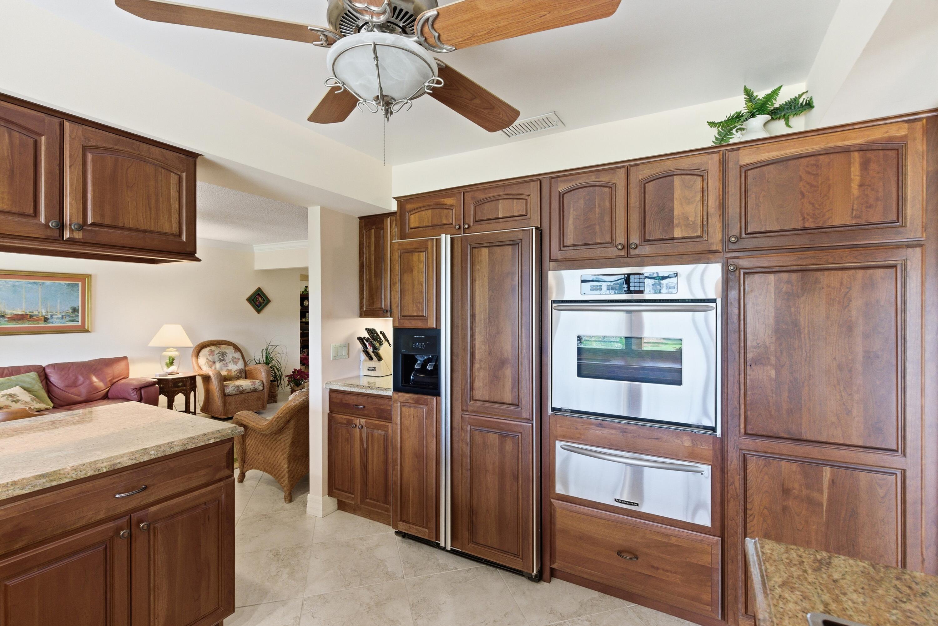 5081 Southeast Burning Tree Circle Stuart, FL 34997 - Photo 22 of 72 a kitchen with granite countertop stainless steel appliances and wooden cabinets
