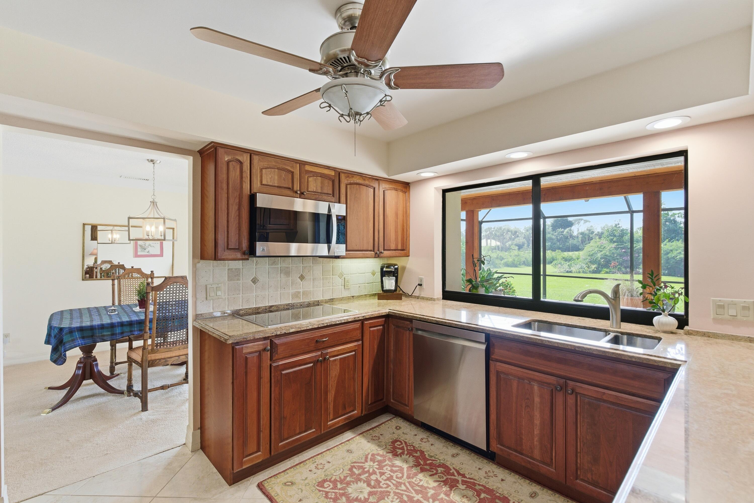 5081 Southeast Burning Tree Circle Stuart, FL 34997 - Photo 23 of 72 a kitchen with a sink stove and microwave