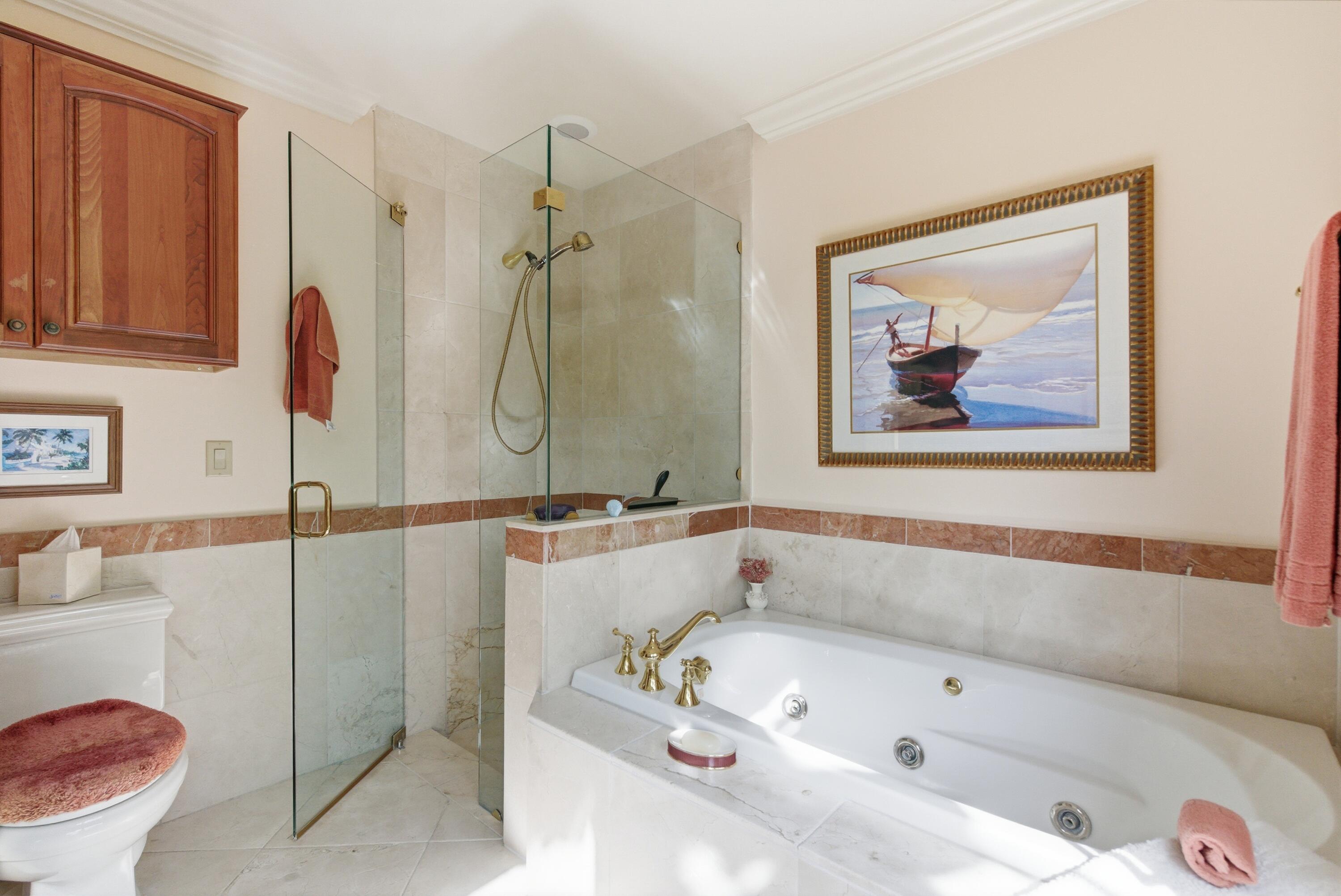 5081 Southeast Burning Tree Circle Stuart, FL 34997 - Photo 32 of 72 a bathroom with a tub a sink and a shower