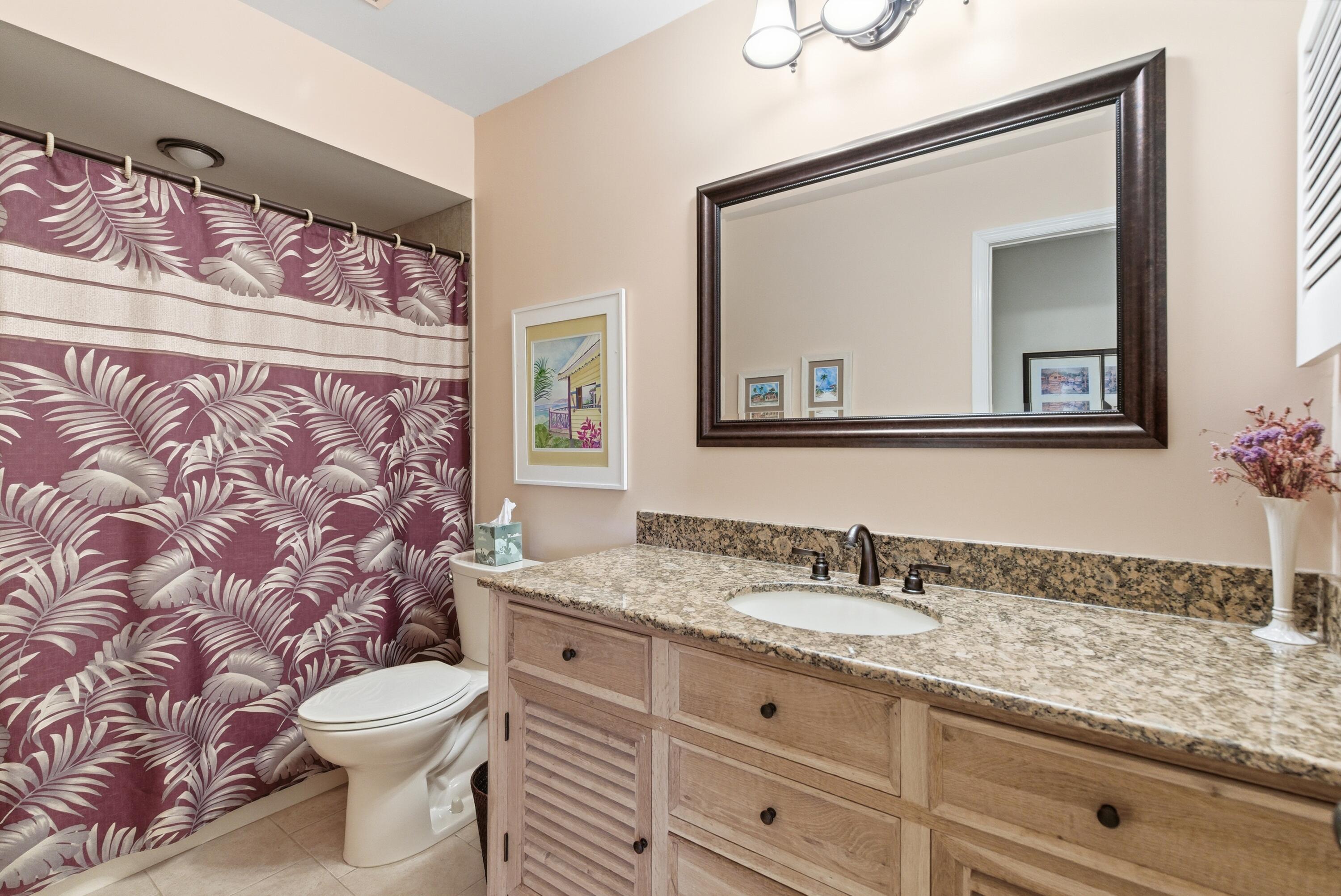 5081 Southeast Burning Tree Circle Stuart, FL 34997 - Photo 39 of 72 a bathroom with a granite countertop toilet sink and mirror