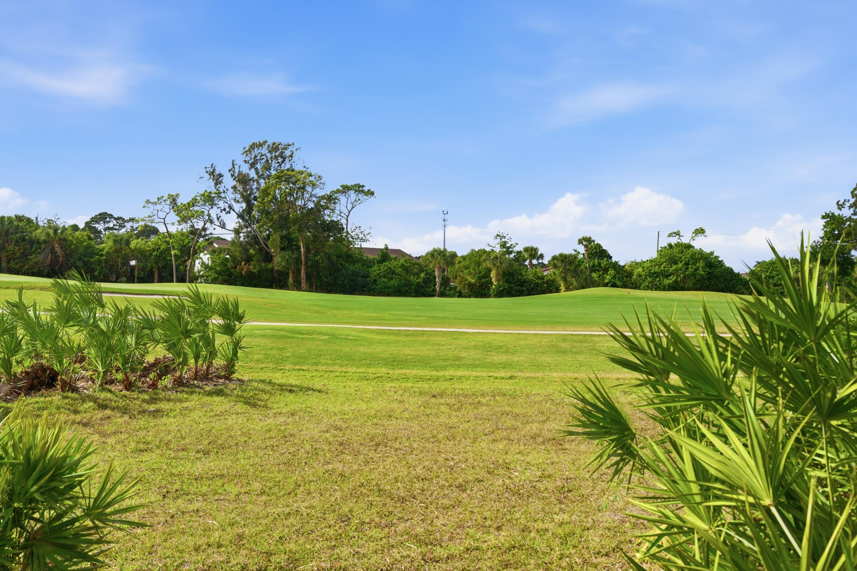 5081 Southeast Burning Tree Circle Stuart, FL 34997 - Photo 52 of 72 a view of a golf course with a lake