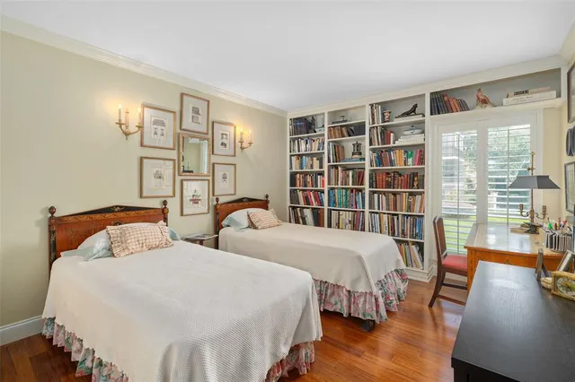 a bedroom with two beds and a book shelf