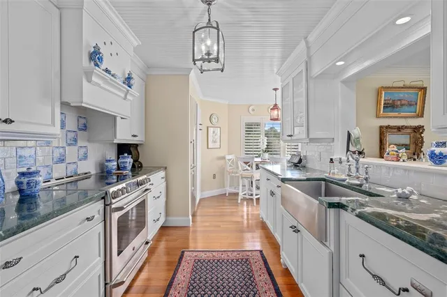 a large kitchen with stainless steel appliances granite countertop a lot of counter space and wooden floors