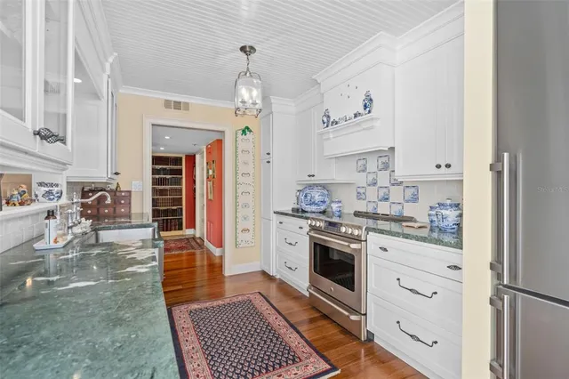 a kitchen with white cabinets and appliances