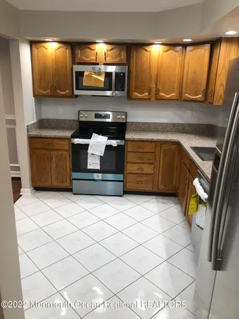a kitchen with stainless steel appliances kitchen island granite countertop a sink and a stove