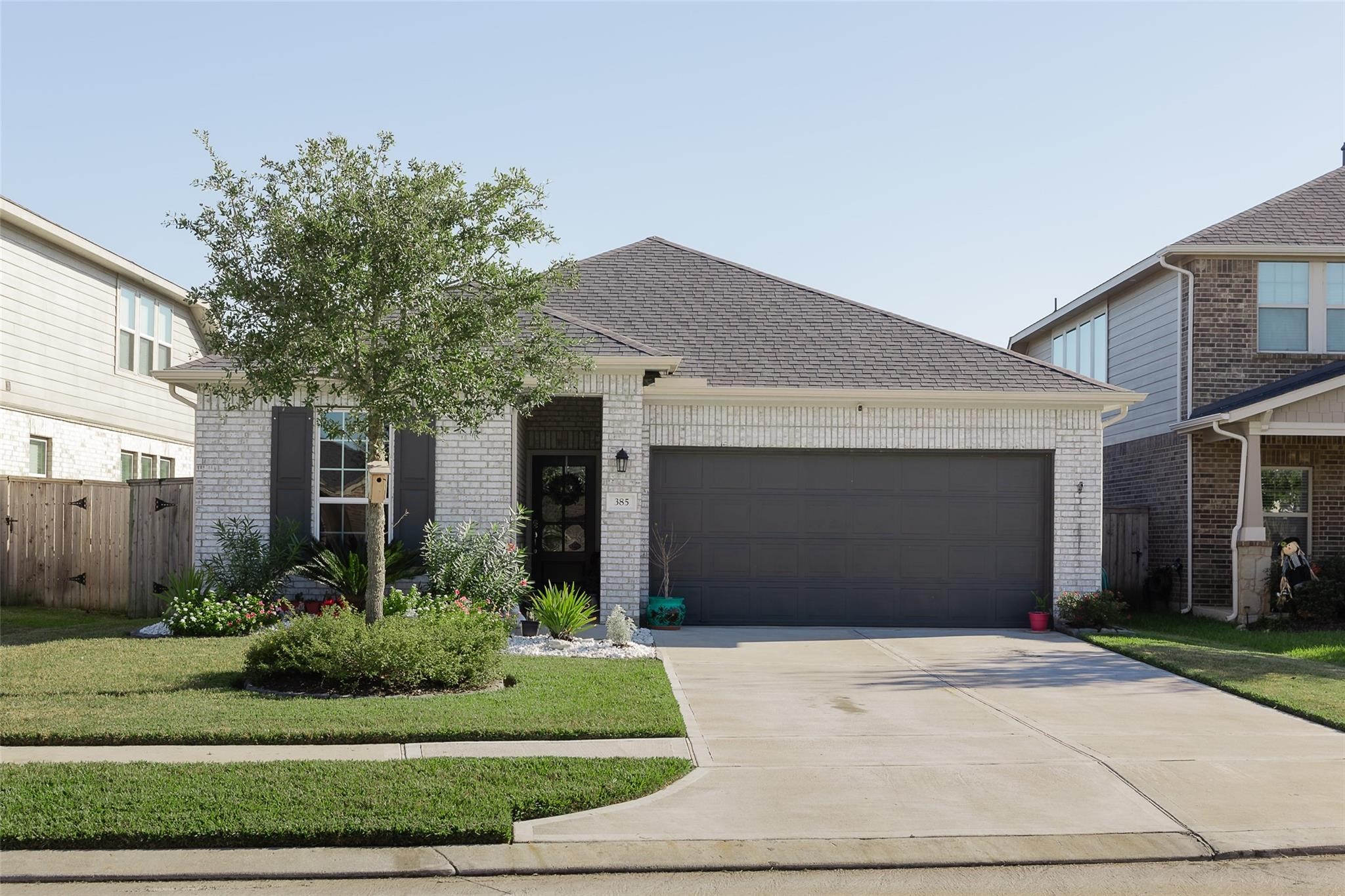 385 Weimer Lagoon Road La Porte, TX 77571 - Photo 1 of 22 This modern single-story home features a brick exterior with a dark garage door and a neatly landscaped front yard