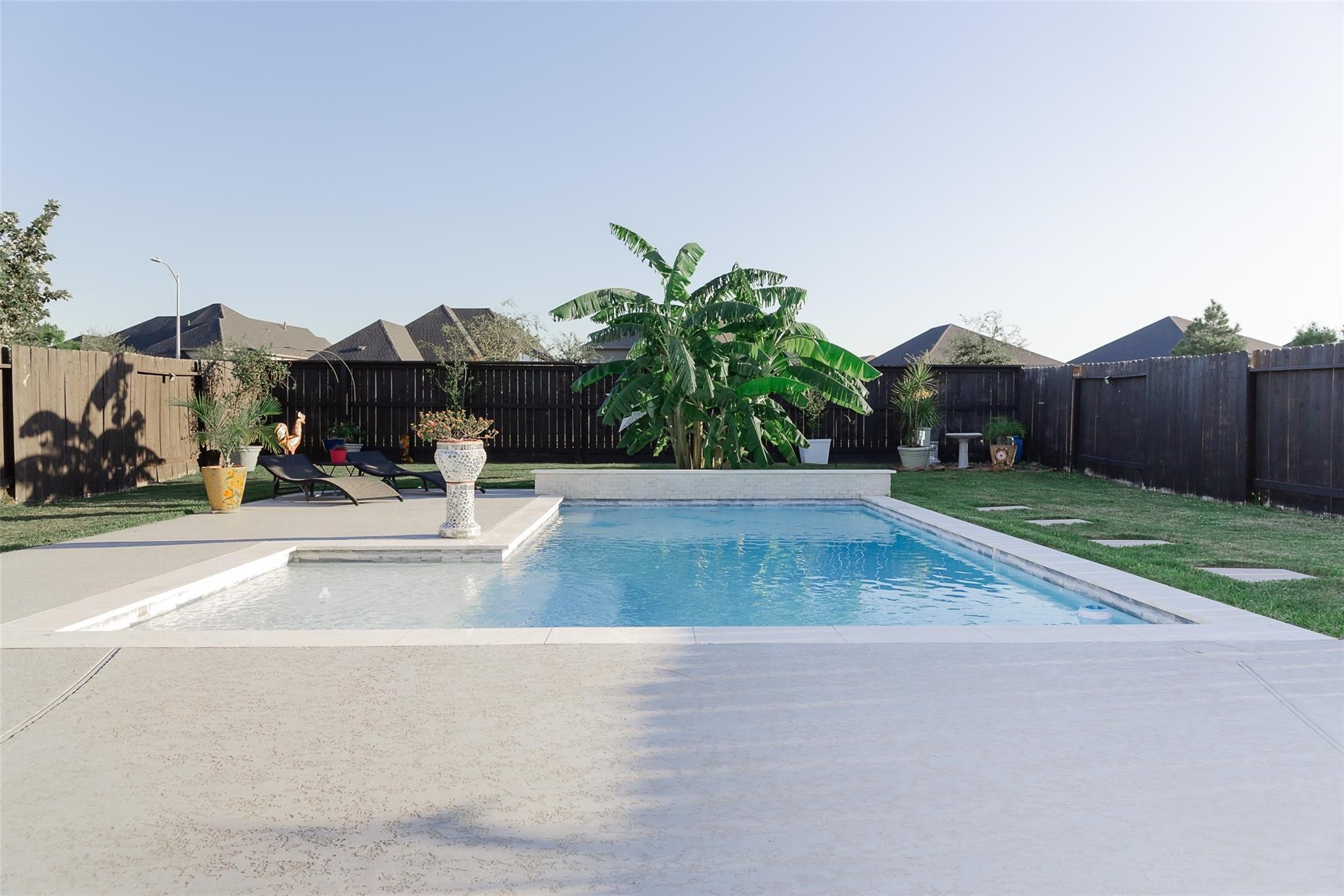 385 Weimer Lagoon Road La Porte, TX 77571 - Photo 22 of 22 This backyard features a spacious in-ground pool and lush green back yard, ideal for outdoor gatherings and leisure.