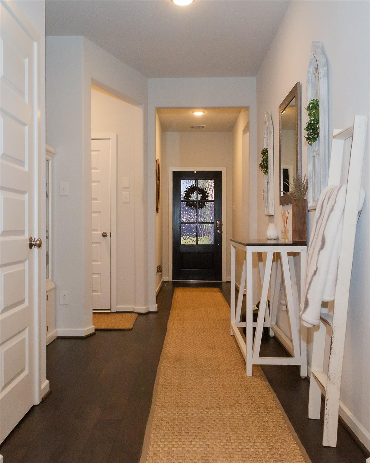 385 Weimer Lagoon Road La Porte, TX 77571 - Photo 3 of 22 Bright and welcoming hallway with dark wood flooring. The front door features a glass panel adding charm and natural light.