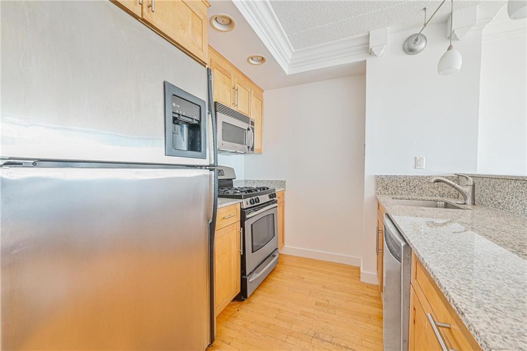 53 Boerum Place, Unit 7C Brooklyn, NY 11201 - Photo 2 of 7 a kitchen with granite countertop a sink and a refrigerator