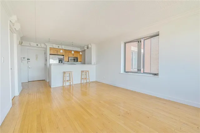 a view of empty room with kitchen and window