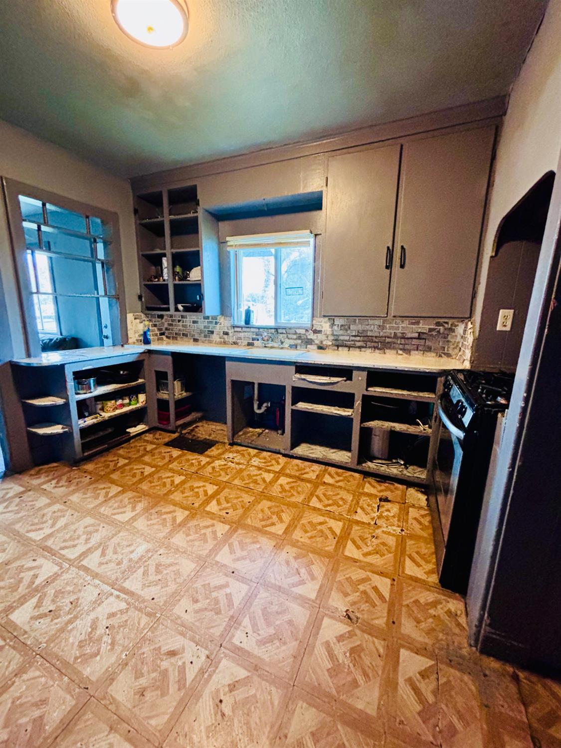 1141 E Street Stockton, CA 95205 - Photo 4 of 13 a view of kitchen with kitchen island granite countertop a sink stove and cabinets
