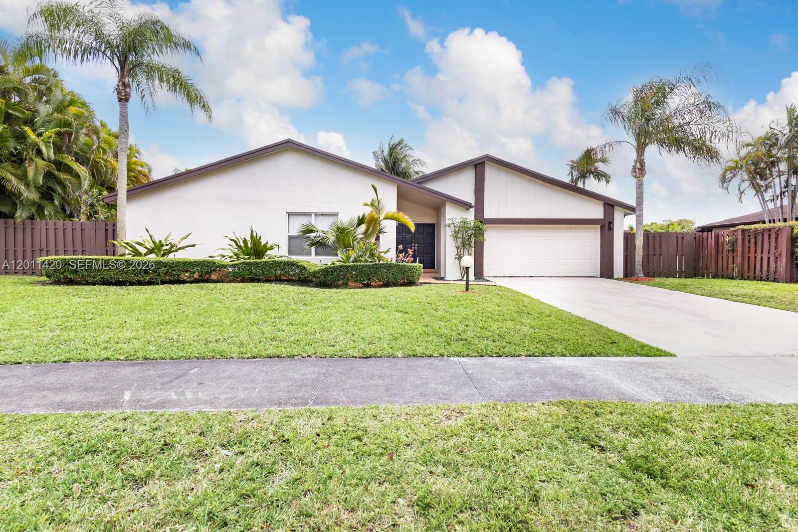 13530 Southwest 109th Terrace Miami, FL 33186 - Photo 1 of 18 a front view of a house with a yard and garage