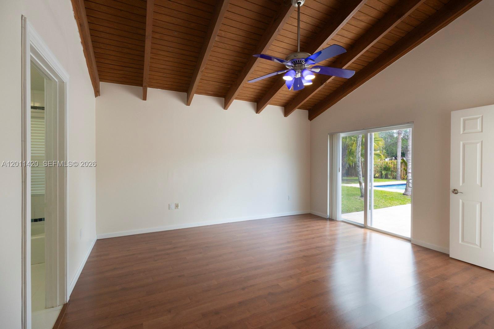 13530 Southwest 109th Terrace Miami, FL 33186 - Photo 13 of 18 a view of an empty room with wooden floor and a ceiling fan
