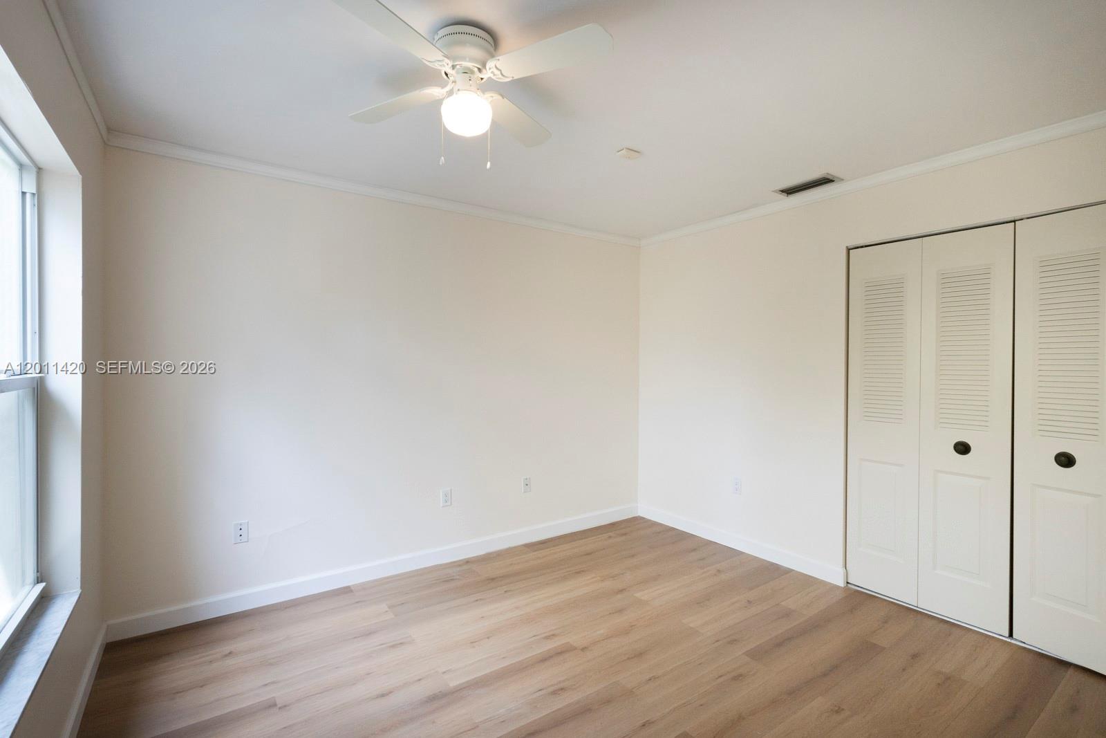 13530 Southwest 109th Terrace Miami, FL 33186 - Photo 17 of 18 an empty room with wooden floor and a ceiling fan