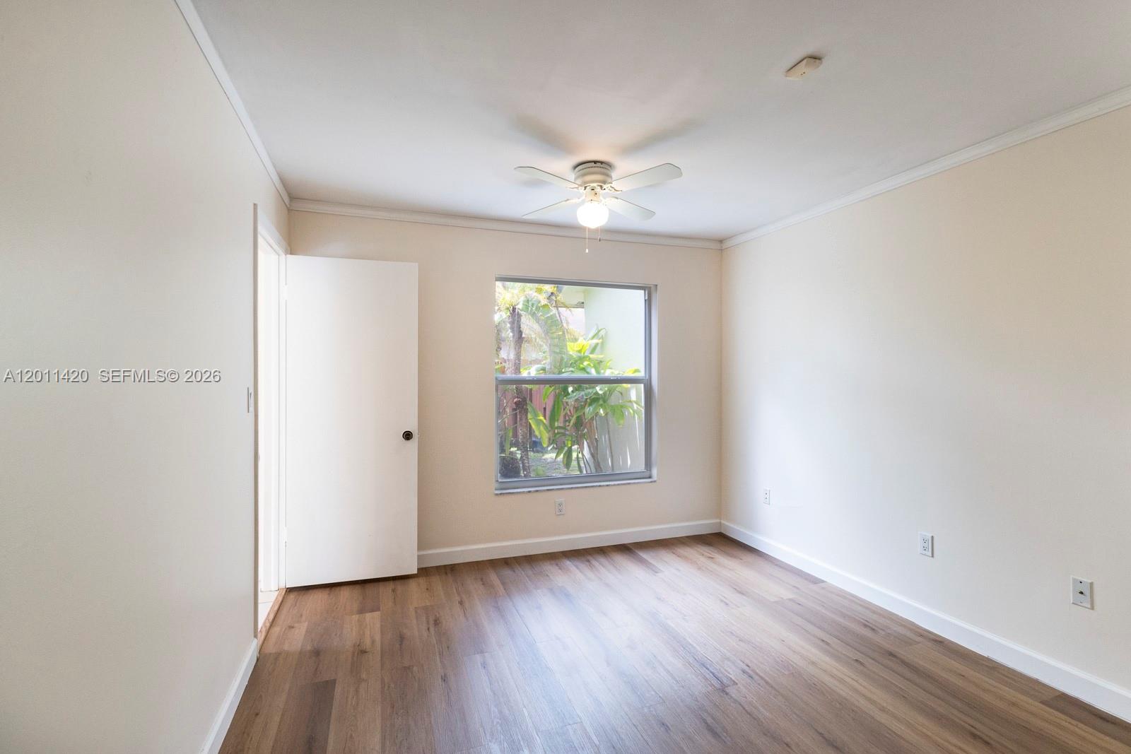 13530 Southwest 109th Terrace Miami, FL 33186 - Photo 18 of 18 an empty room with wooden floor and windows
