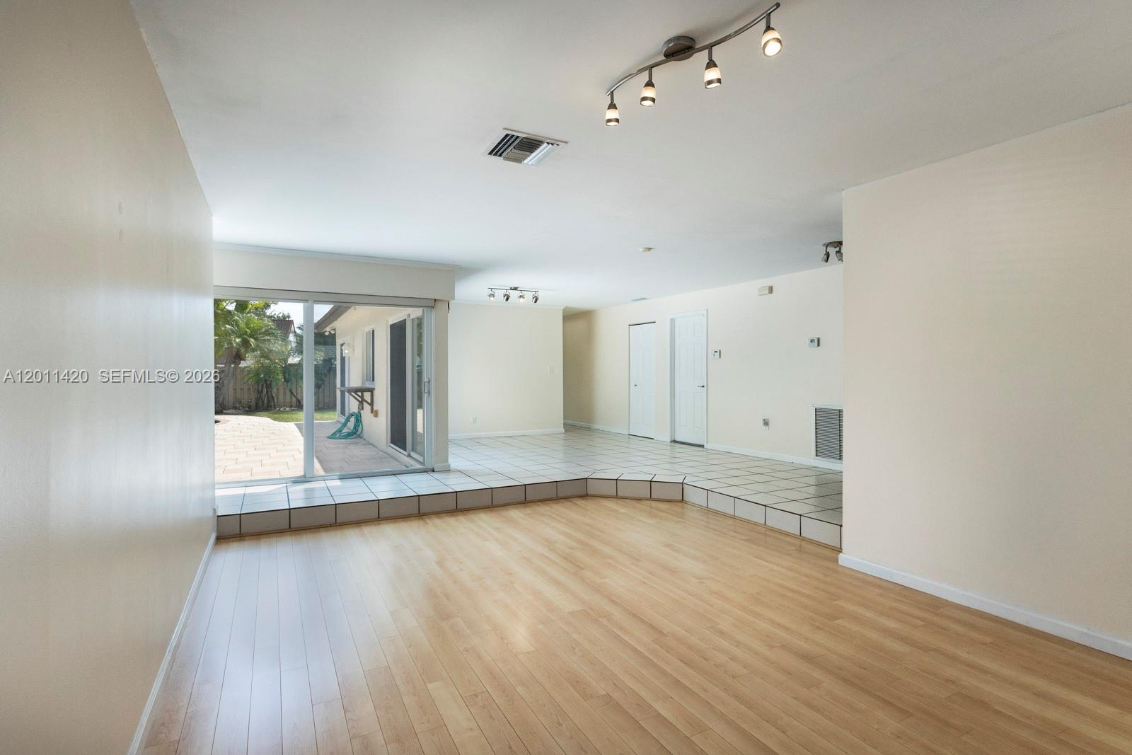 13530 Southwest 109th Terrace Miami, FL 33186 - Photo 4 of 18 wooden floor in an empty room with a window
