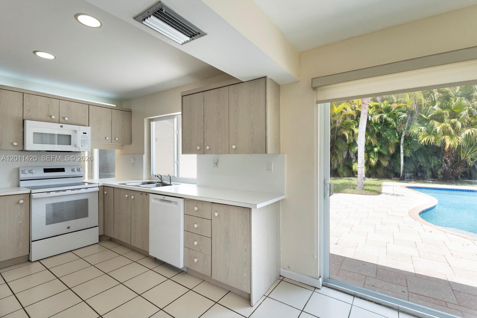 13530 Southwest 109th Terrace Miami, FL 33186 - Photo 9 of 18 a kitchen with a stove a sink and a refrigerator
