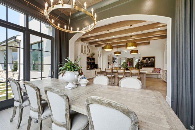 71 Farm Road Midway, UT 84049 - Photo 22 of 92 Dining area featuring a large wood-finish table, oversized chandelier with candelabra bulbs, and expansive black-framed windows