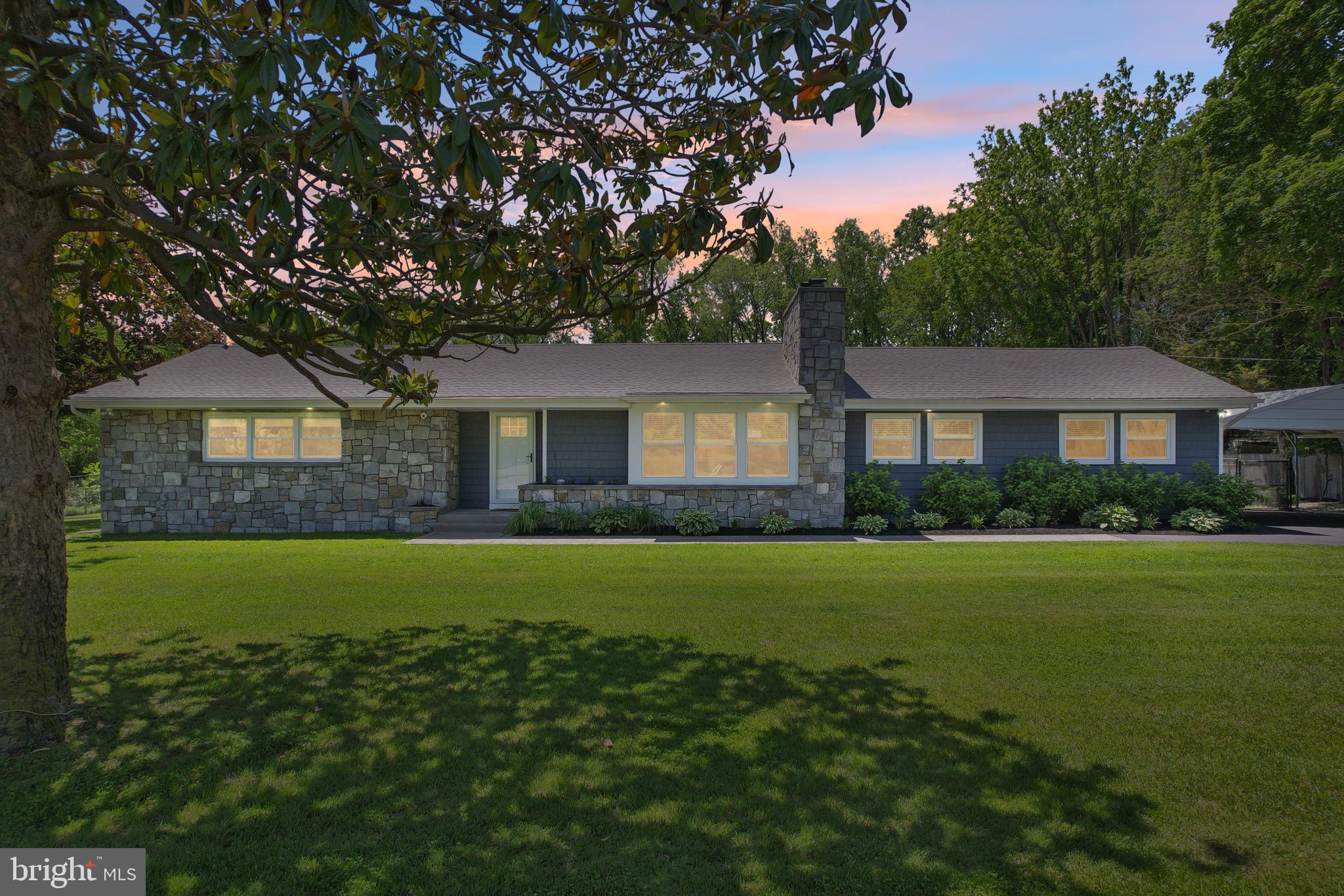 a front view of a house with a yard and trees