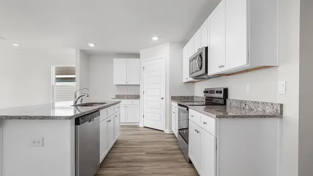 a view of kitchen with sink and refrigerator