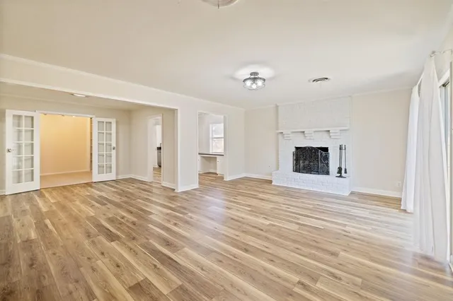 a view of empty room with wooden floor and fireplace