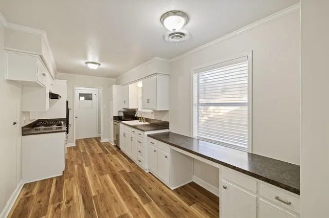 a view of a room with wooden floor and a bathroom