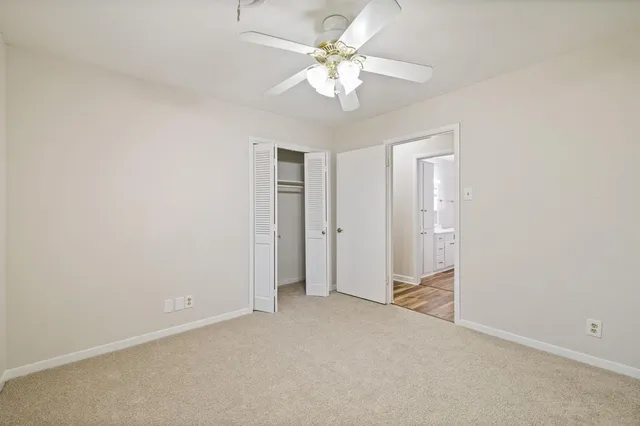 an empty room with chandelier fan