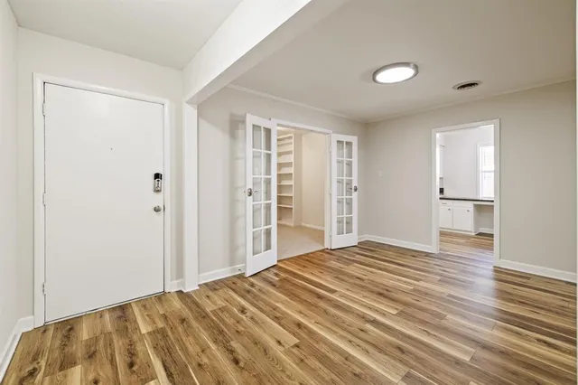 a view of empty room with wooden floor and entryway
