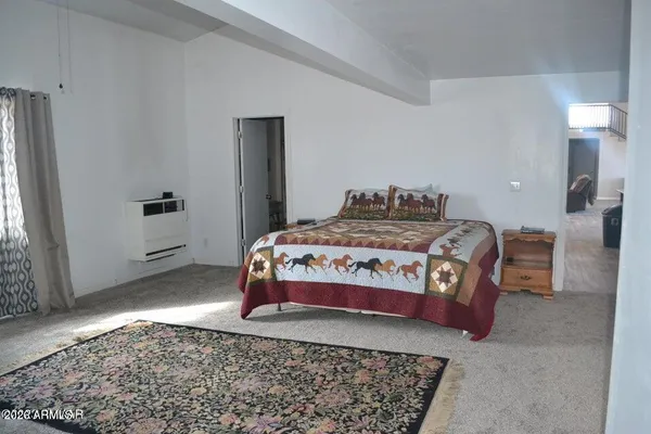 a bedroom with a bed and flat screen tv