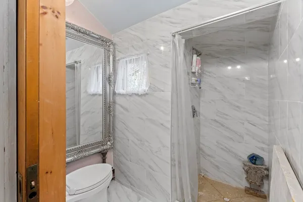 a bathroom with a granite countertop shower mirror and toilet