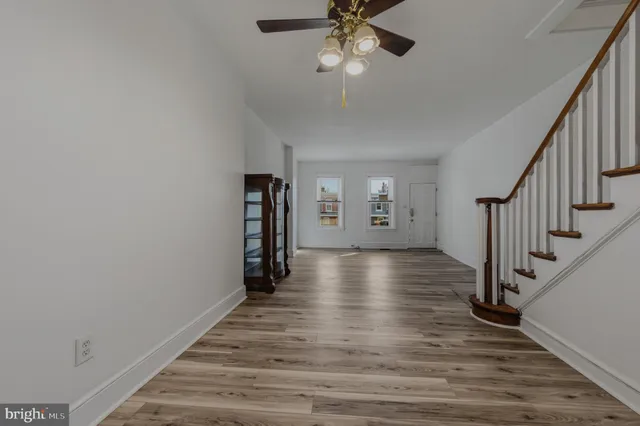 a view of a hallway with wooden floor and staircase