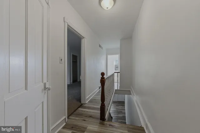 a view of a hallway with wooden floor and staircase
