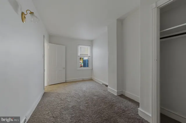 a view of an empty room and closet area