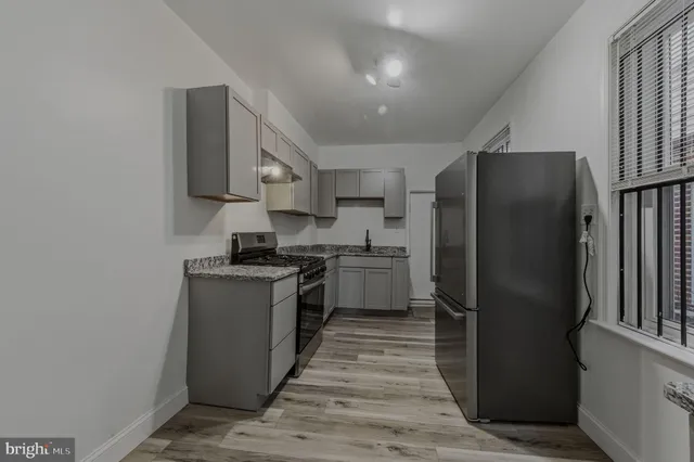 a kitchen with stainless steel appliances granite countertop a refrigerator stove and sink