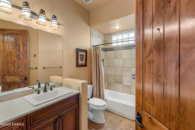 a bathroom with a granite countertop sink toilet a shower and a mirror