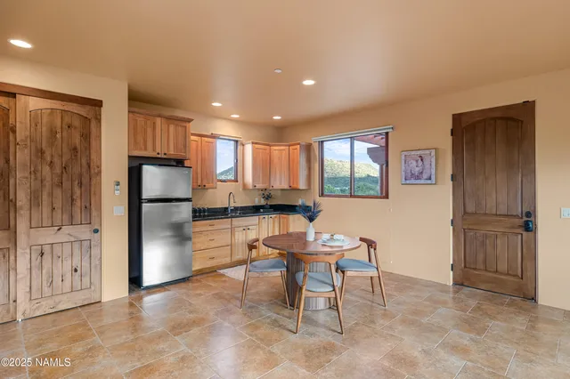 a kitchen with stainless steel appliances kitchen island granite countertop a refrigerator and cabinets