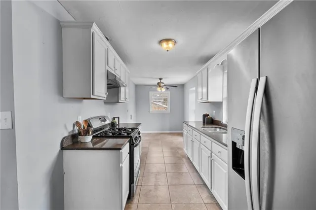 a kitchen with stainless steel appliances granite countertop grey cabinets a stove a sink and dishwasher