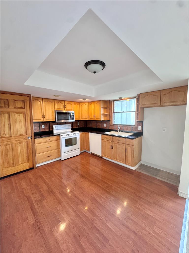 8325 Schantz Road Breinigsville, PA 18031 - Photo 7 of 21 A functional kitchen boasts light wood cabinetry, sleek black countertops, and durable laminate flooring.