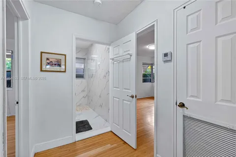 a view of a hallway with wooden floor and closet