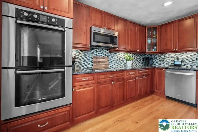 a kitchen with granite countertop wooden cabinets stainless steel appliances and a granite counter tops