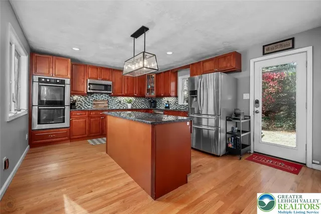 a kitchen with stainless steel appliances granite countertop a refrigerator a stove top oven a sink and dishwasher