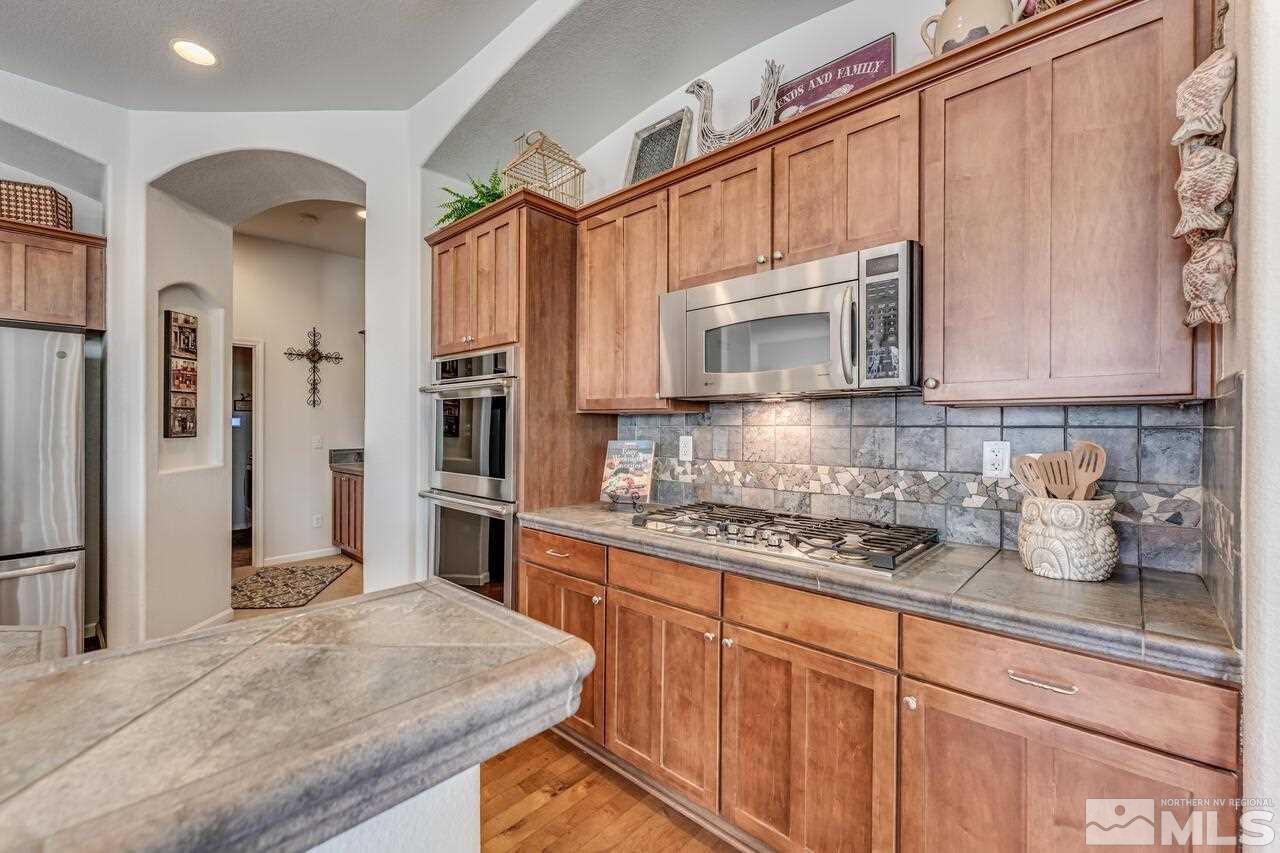 1635 Gulch Way Reno, NV 89521 - Photo 12 of 39 a kitchen with stainless steel appliances granite countertop a stove a sink and a microwave