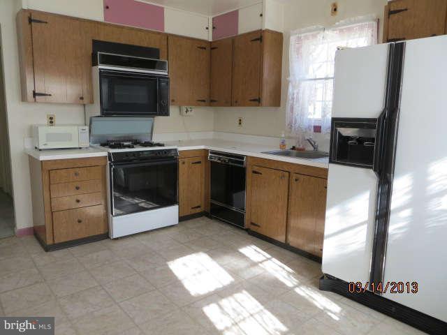 408 Crosby Road Baltimore, MD 21228 - Photo 4 of 17 a kitchen with stainless steel appliances granite countertop a stove a sink and a refrigerator
