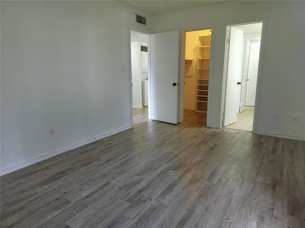 an empty room with wooden floor and closet