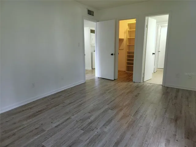 an empty room with wooden floor and closet