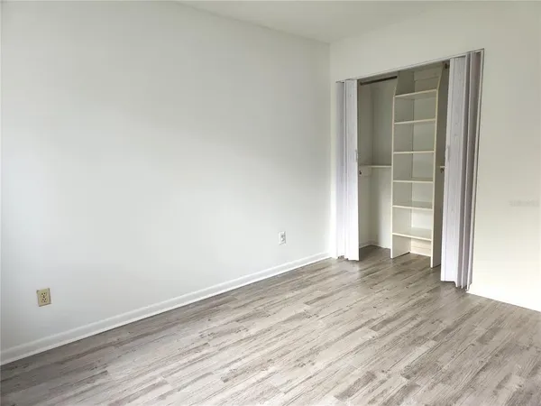 an empty room with wooden floor and closet