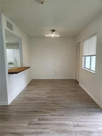 a view of empty room with wooden floor